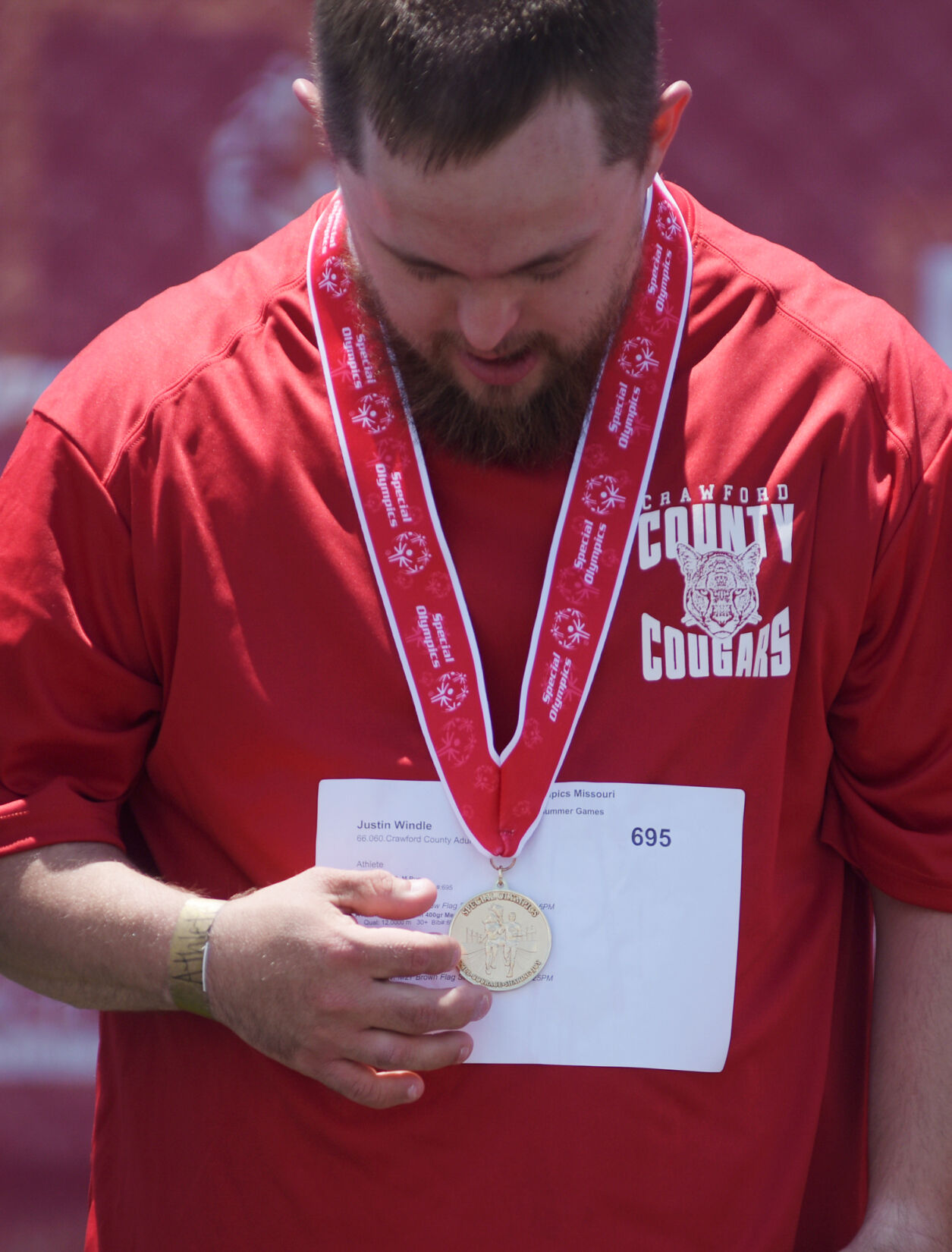 Justin Windle looks at his first place medal